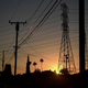 The sun sets behind power lines in Rosemead, California on June 14, 2021.